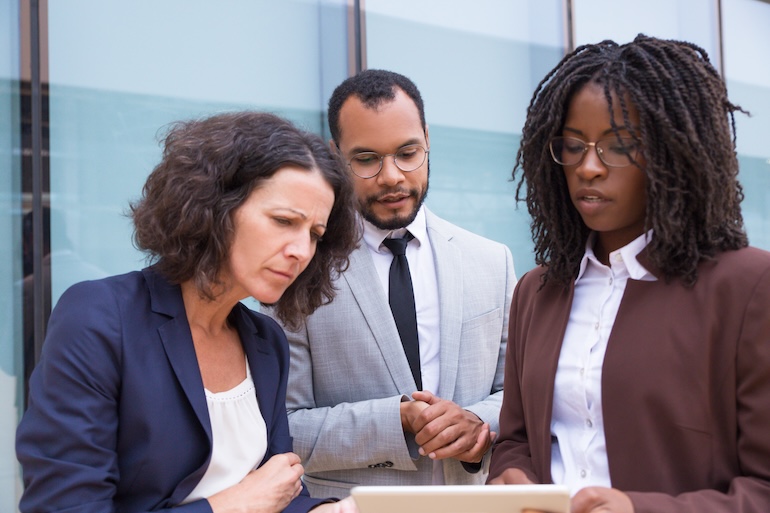 Agent showing presentation to customer three coworkers overlooking fines for non compliance