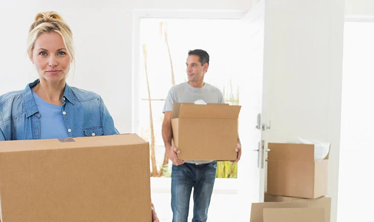 Movers carrying boxes into a home