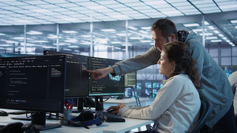 coworker pointing at screen showing the future of asset management on a device