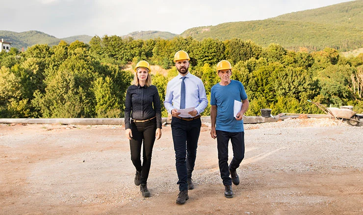 Engineers in hard hats walking across a construction site