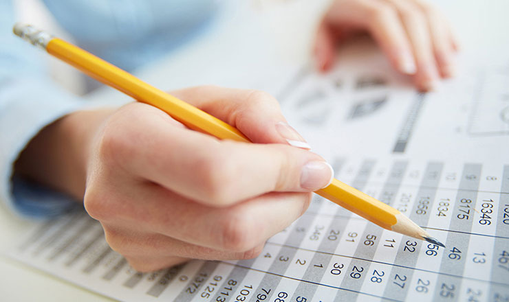close up of hands marking depreciation in a balance sheet