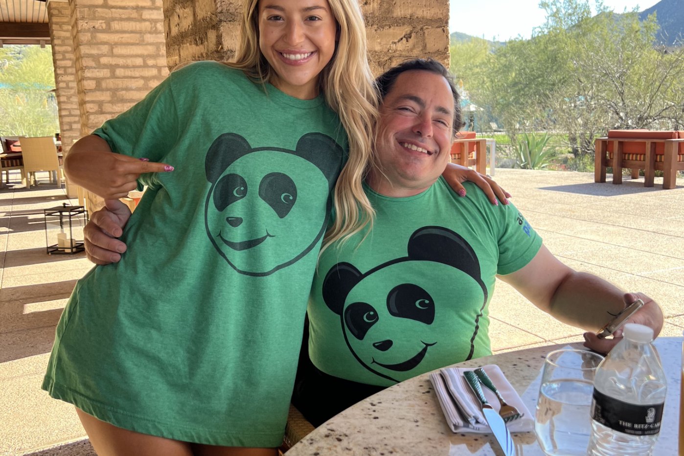 Two Asset Panda team members smiling together in panda t-shirts