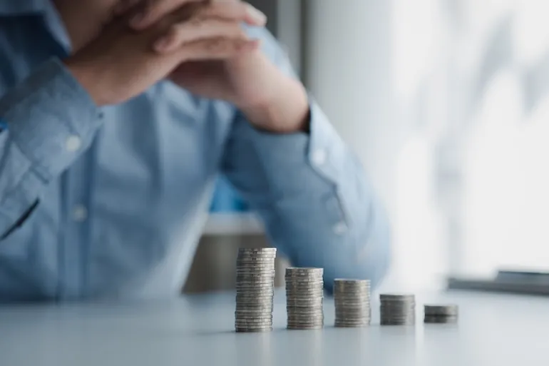 man over coin stacks contemplating depreciation of it assets