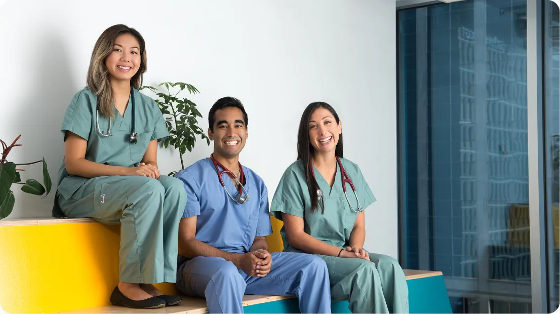 Medical residents in scrubs seated together