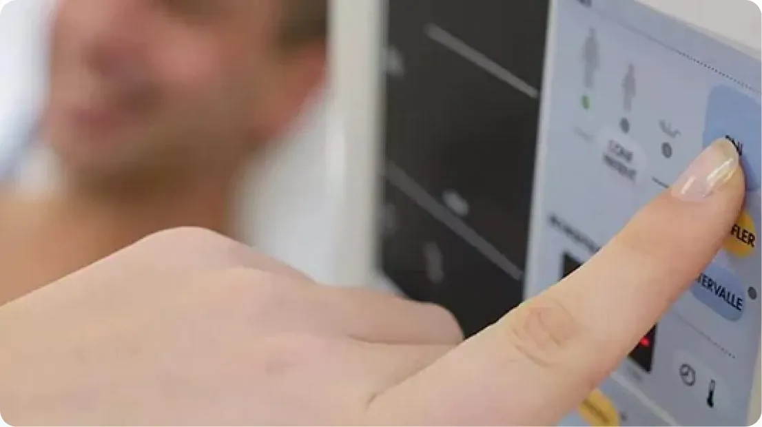 Hand pressing a button on a medical equipment control panel