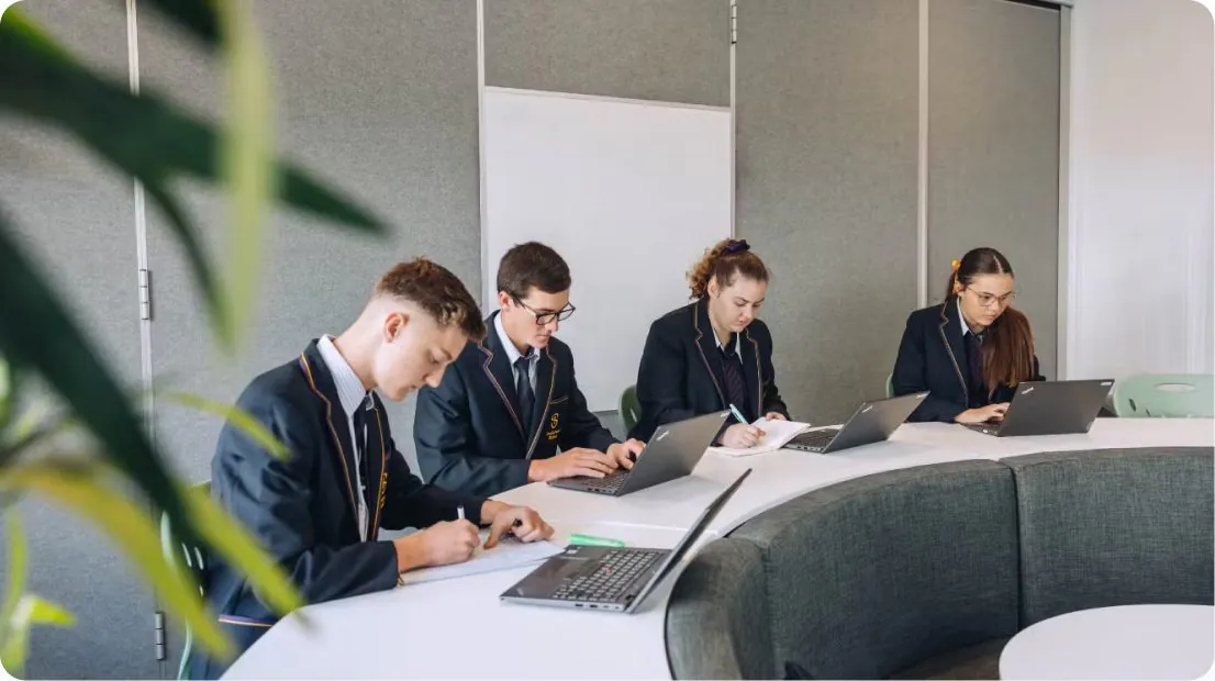 Students working on laptops in a classroom